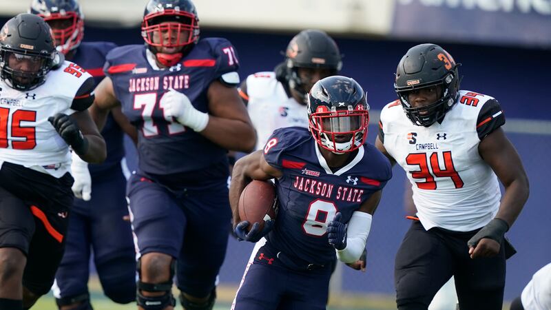 Jackson State running back JD Martin (8) carries the ball for a first down as he is chased by...
