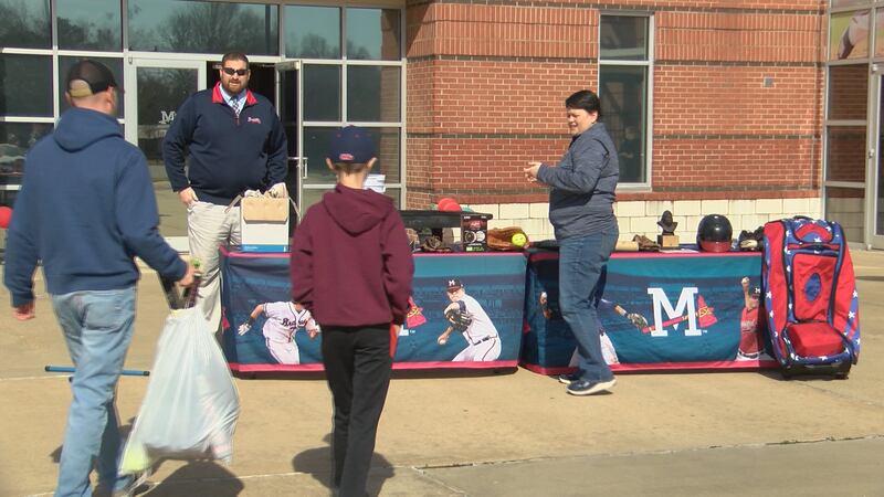 People drop off baseball and softball equipment for the M Braves equipment drive