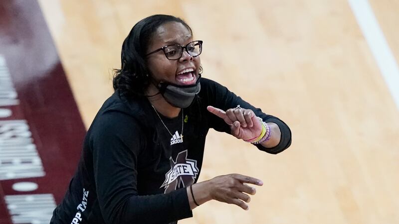 Mississippi State coach Nikki McCray-Penson lowers her mask as she calls to players during the...