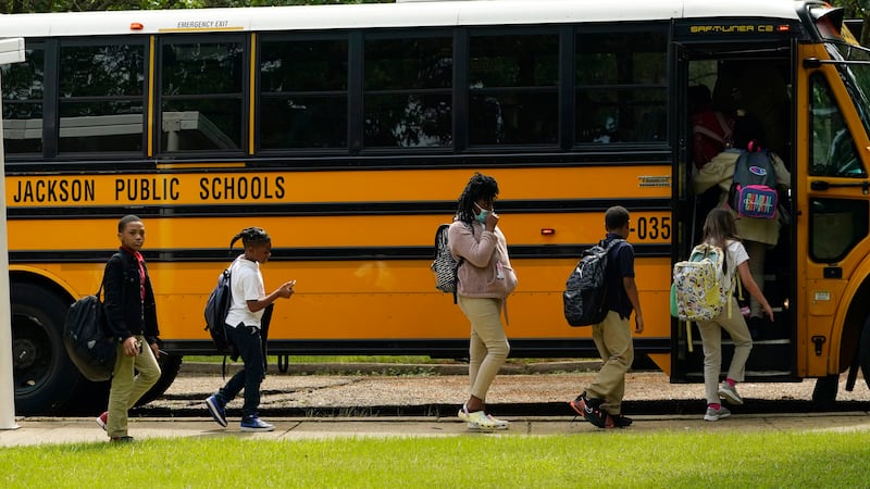 FILE - Spann Elementary School students board a school bus following a full day of in-school...