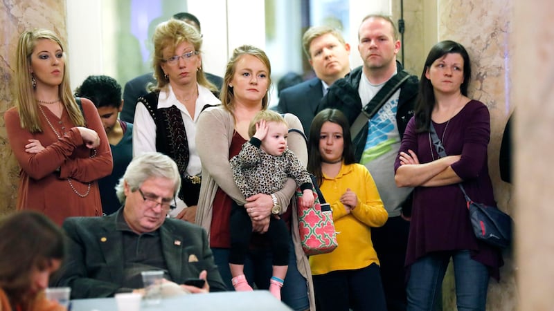 FILE - Parents with their children and medical professionals listen to testimony from people...